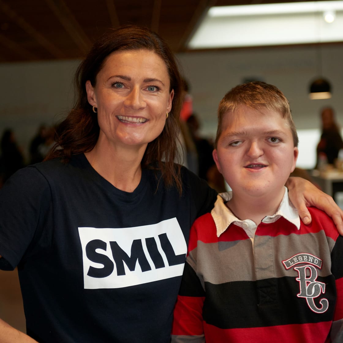 Voksen med smil tshirt holder armen rundt om barn