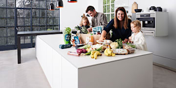 En familie der pakker deres BilkaToGo ordre ud i køkkenet. Køb dagligvarer hos BilkaToGo.
