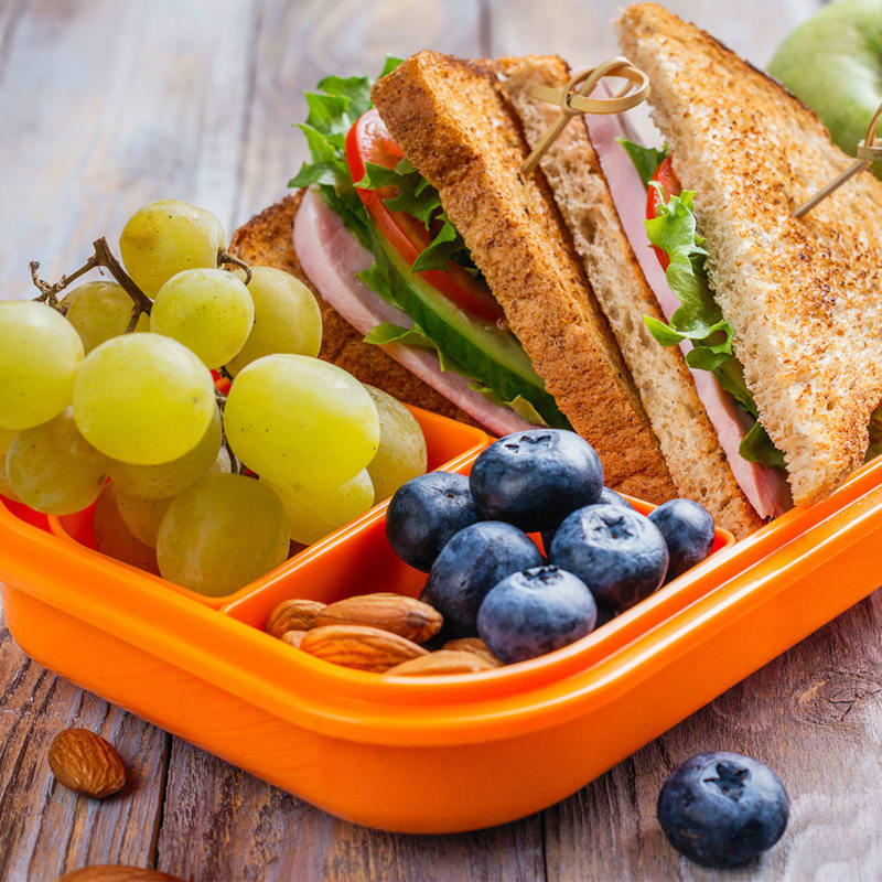 Madpakke med sandwich, vindruer, blåbær og mandler