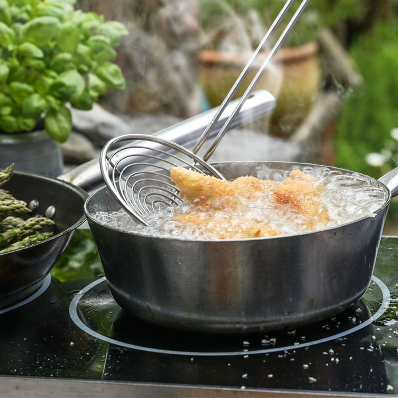 Person friterer kylling i gryde