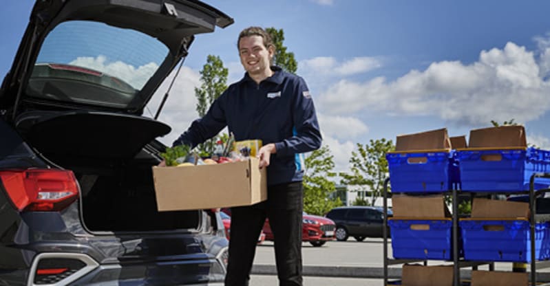 Bilka medarbejder afleverer BilkaToGo dagligvarer direkte i bagagerummet. 