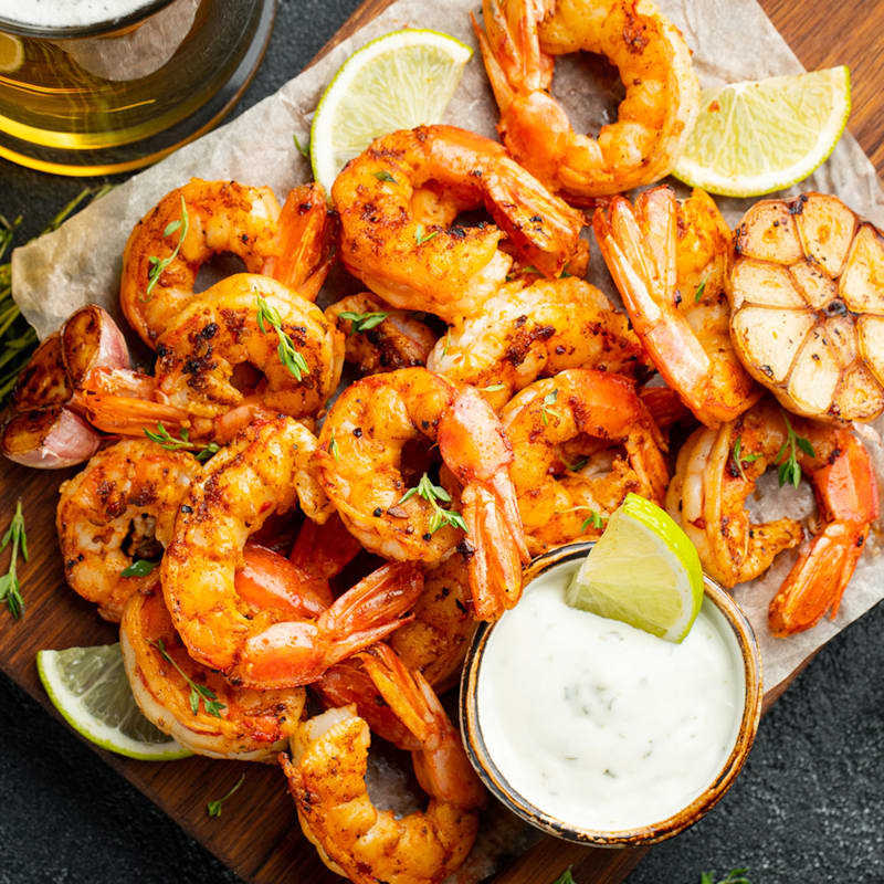 Grillede tigerrejer på bord med dressing og mayo