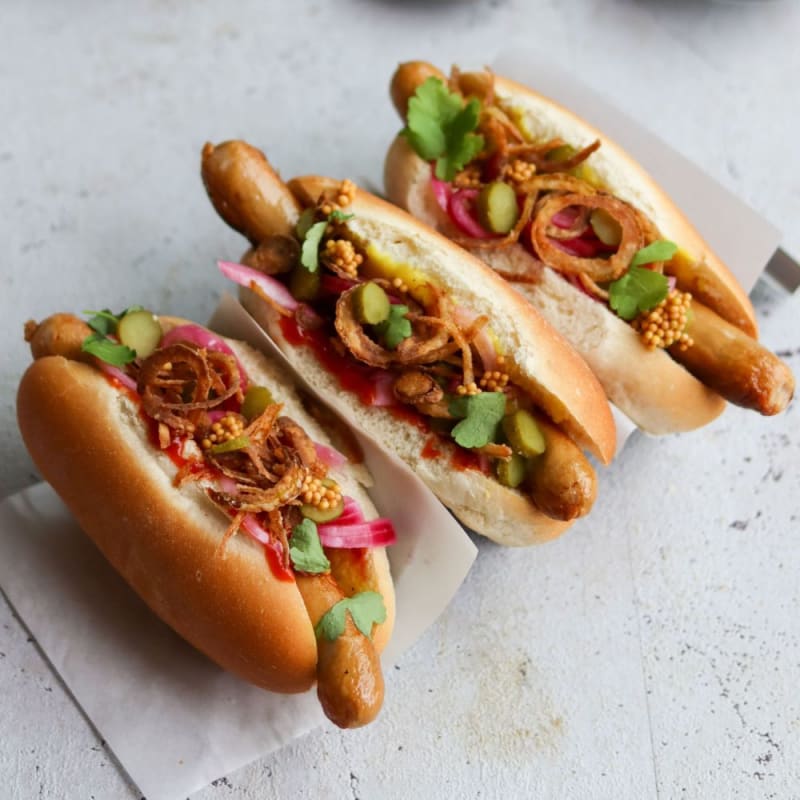 Hotdogs med syltede rødløg, ristede løg og sennepsfrø