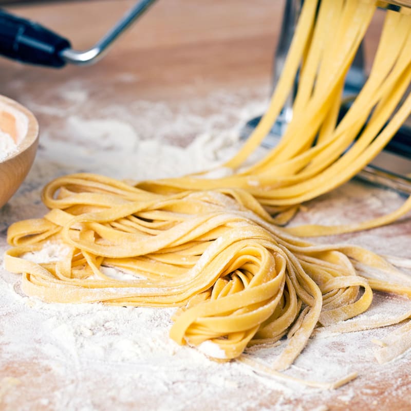 Frisk pasta på bord med pastamaskine
