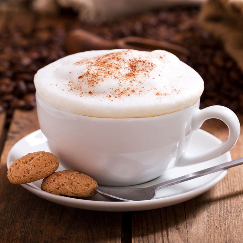 Babyccino i kaffekop med cookies ved siden af