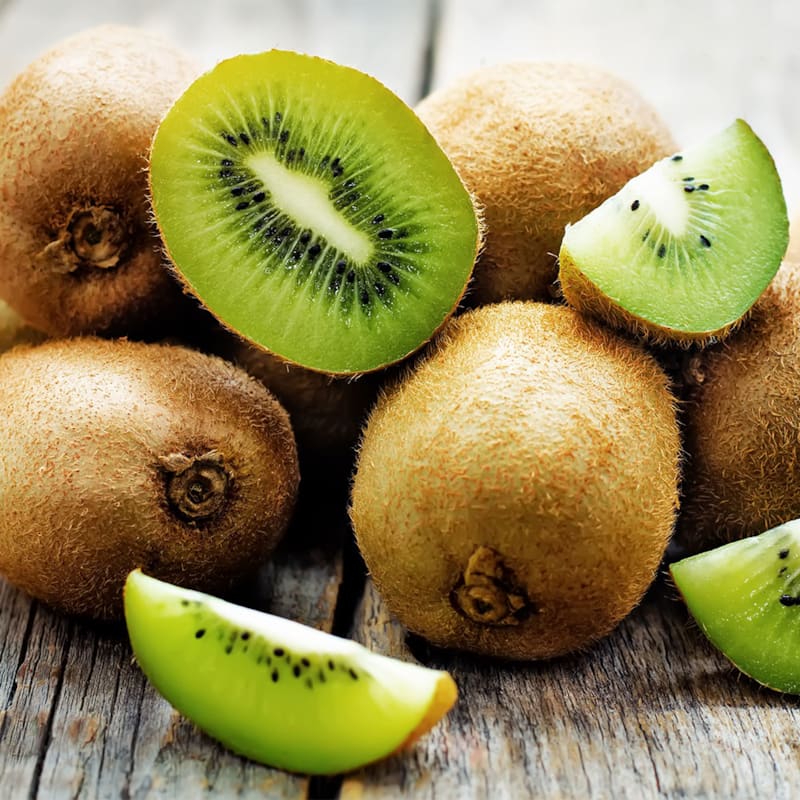 Hele og halverede kiwier på bord