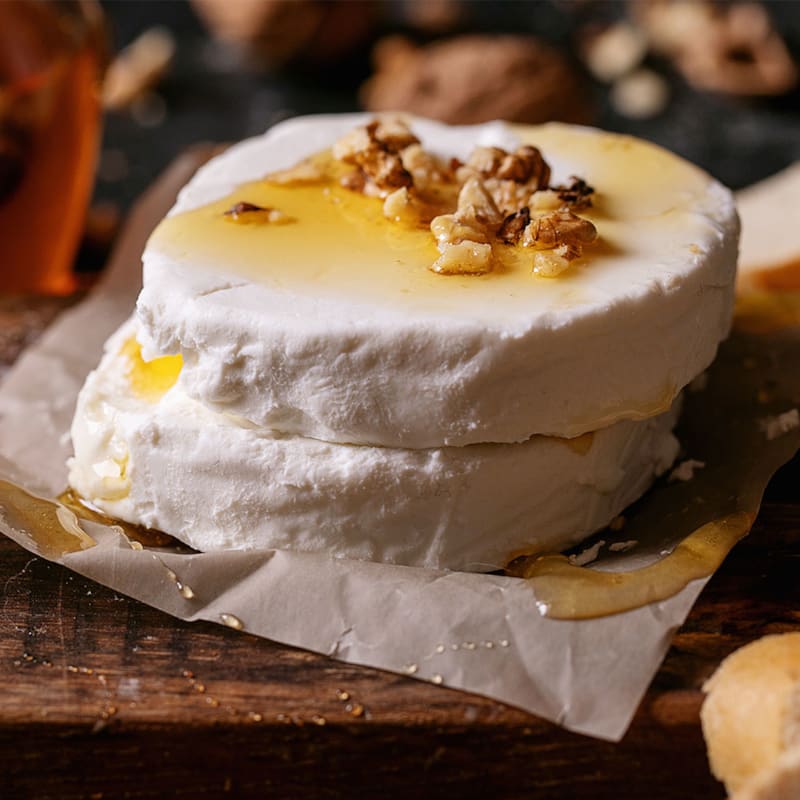 Gedeost med honning og nødder på skærebræt