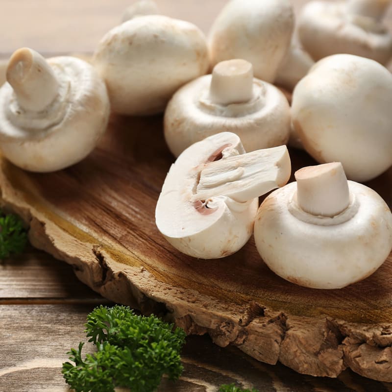 Hvide champignon på skærebræt