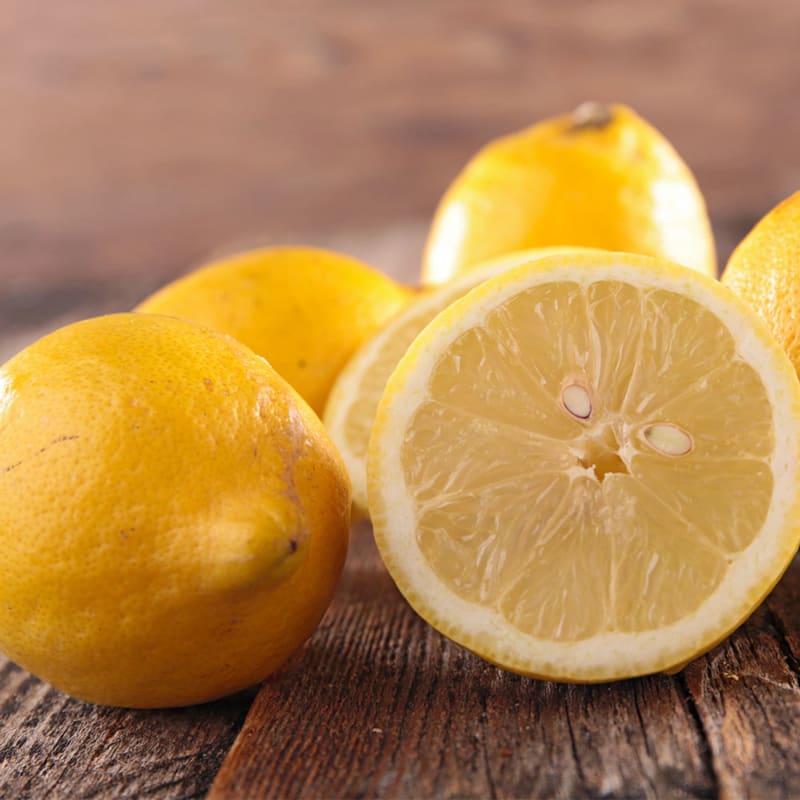 Friske gule citroner på bord