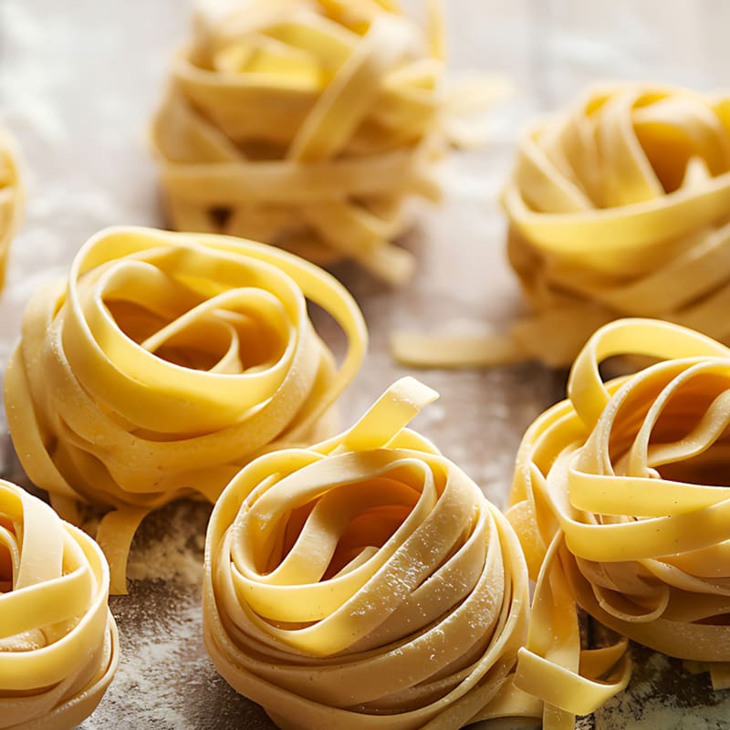 Rå reder af tagliatelle pasta på bord
