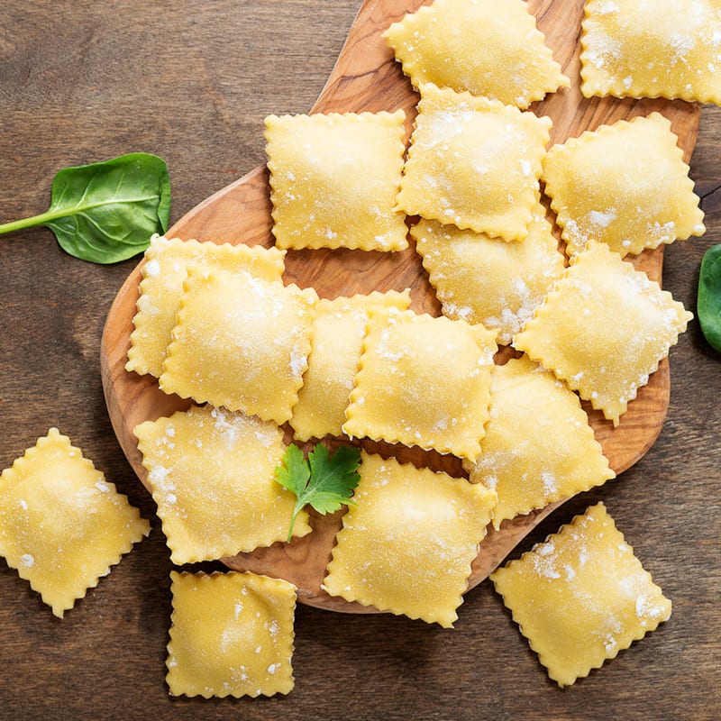 Rå ravioli pasta på skærebræt